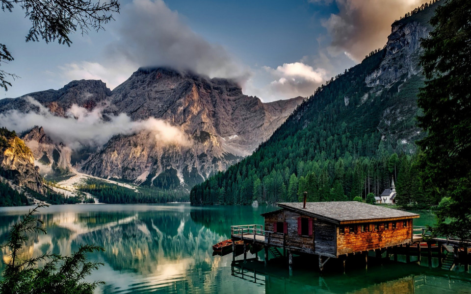Holzhütte auf einem See mit Berglandschaft